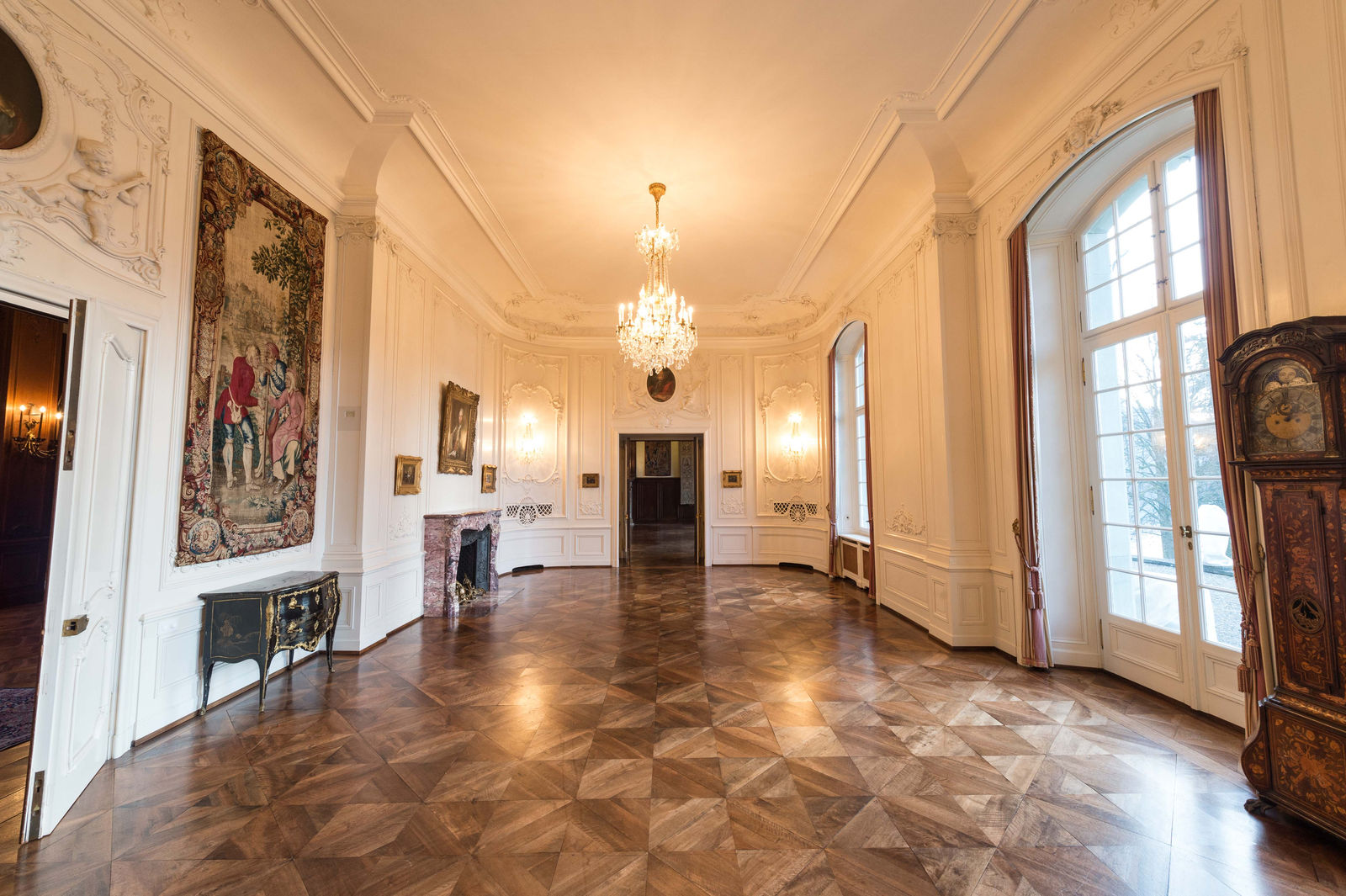 Heller historischer Saal mit Stuck, Parkett und Kristallleuchter